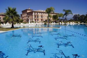 una gran piscina de agua azul frente a un edificio en BV Airone Resort, en Marina di Sibari