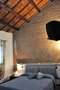 a bedroom with a brick wall and a bed at Corte Dossello in Migliaro