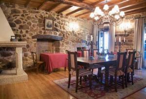 una sala da pranzo con tavolo e parete in pietra di O Retiro do Conde a Villaza