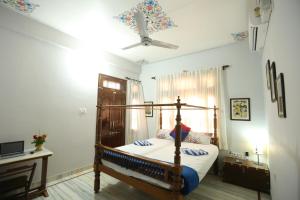 a bedroom with a bed and a ceiling fan at Harsidhi Haveli in Bikaner +90 photos