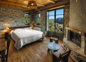 a bedroom with a bed and a fireplace at Pritanio in Polídhroson +249 photos