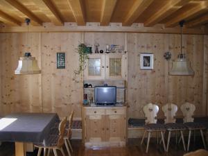 a dining room with a television and a table and chairs at Gasthof Lechner in Rasun di Sopra