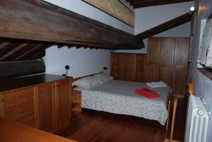 a bedroom with a bed in a room with wooden floors at Agriturismo San Vettore in Gambassi Terme