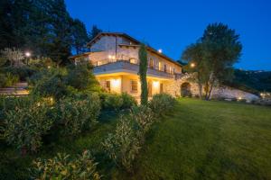 una grande casa in pietra con un cortile di notte di Antica Fonte ad Assisi