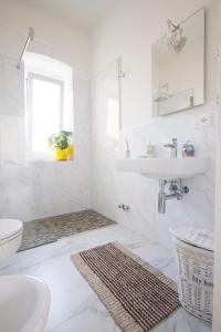 ein weißes Bad mit einem Waschbecken und einem WC in der Unterkunft La Casa del Vento in La Spezia