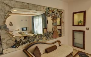 a living room with a large mirror and a couch at Iakovakis Suites & Spa in Koropi