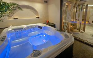 a bathroom with a blue tub in a room at Iakovakis Suites & Spa in Koropi