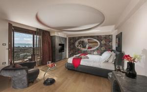 a bedroom with a large bed and a large mirror at Iakovakis Suites & Spa in Koropi