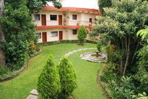 a house with a large garden and trees at Hotel La Casona del Llano in Oaxaca City