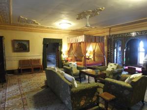 a living room with couches and a table at Udai Bilas Palace in Dūngarpur