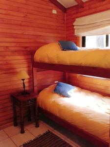 เตียงในห้องที่ Cabañas Piremapu