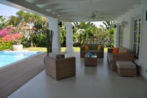 a porch with couches and chairs next to a pool at Balinese villa with private pool in Hua Hin
