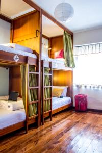 a room with bunk beds with a laptop and a suitcase at El Patio Hostel Quito in Quito