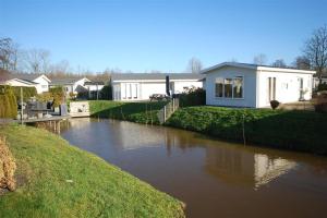 une maison avec une rivière devant elle dans l'établissement Holiday rentals, à Velsen-Zuid