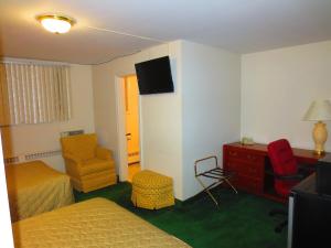 a hotel room with a bed and a desk and a chair at Canadiana Motel in Hanover