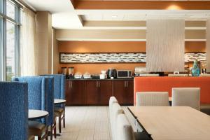 a restaurant with tables and chairs and a kitchen at Country Inn & Suites by Radisson, Wolfchase-Memphis, TN in Memphis