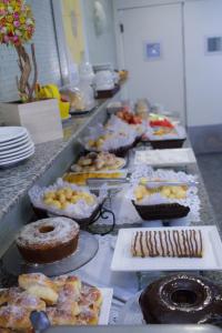 a table topped with lots of different types of pastries at Oft San Conrado Hotel in Goiânia