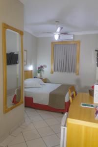 a bedroom with a bed and a mirror at Oft San Conrado Hotel in Goiânia