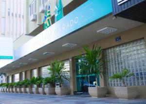 a building with potted plants in front of it at Oft San Conrado Hotel in Goiânia