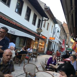 a group of people sitting at tables outside a restaurant at Apartment Sena in Sarajevo