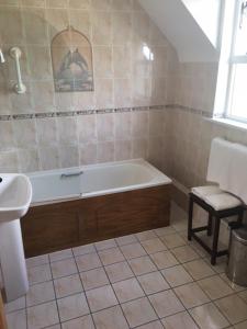 a bathroom with a bath tub and a sink at Keanes of Curraheen in Tralee