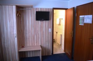 a hotel room with a hallway with a television on the wall at Landgasthof Voltmer in Ramlingen