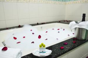 baño con bañera llena de pétalos de rosa roja en Pousada Canasvieiras, en Florianópolis