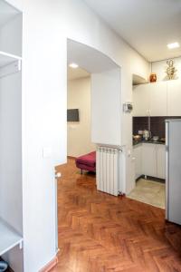 een keuken met witte kasten en een houten vloer bij White Apartment Old Tbilisi in Tbilisi City