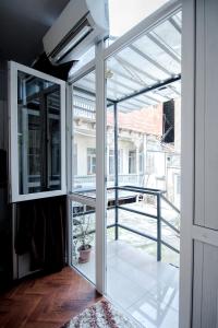 een kamer met glazen schuifdeuren en uitzicht op een balkon bij White Apartment Old Tbilisi in Tbilisi City
