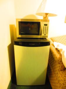 a microwave on top of a trash can next to a bed at Canadiana Motel in Hanover