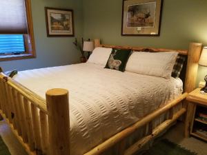 uma grande cama de madeira num quarto com em Two Bears Inn Bed & Breakfast em Red Lodge