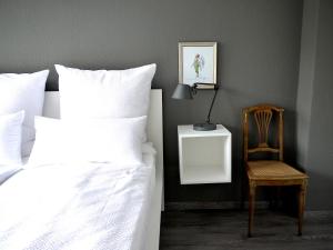 ein Schlafzimmer mit einem Bett, einem Stuhl und einer Lampe in der Unterkunft Lebendiges Linden in Hannover