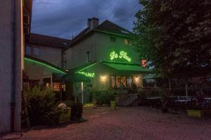 un restaurante con una señal verde en el lateral de un edificio en Hotel Restaurant La Place, en Malay