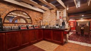 a bar in a restaurant with a brick wall at Best Western Fireside Inn in Kingston