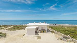 una casa sulla spiaggia con l'oceano sullo sfondo di Magoito1 a Sintra