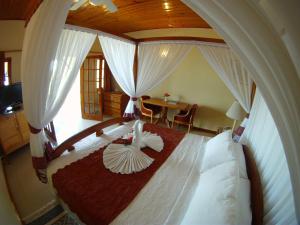 a bedroom with a large bed with a wooden canopy at Charela Inn in Negril