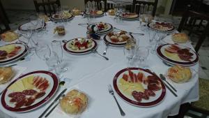 una mesa larga con platos de comida y copas de vino en Hostal Restaurante Rufino, en Berlanga