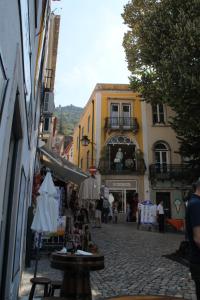 a street with tables and umbrellas in a city at Casa d Sintra in Sintra
