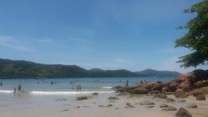 a group of people in the water at a beach at Pousada Seachegue in Ubatuba