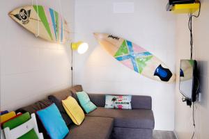 sala de estar con sofá y tablas de surf en la pared en Silver Coast - Casa da Ilha, en Baleal