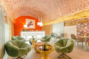 a waiting room with green chairs and orange walls at Hotel Borges Chiado in Lisbon