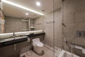 a bathroom with a toilet and a glass shower at Zensation The Residence Bangkok in Bangkok +44 photos
