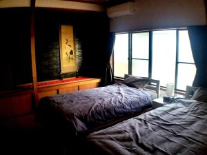 a bedroom with a bed and a large window at Tsudoh Stay Hikoso in Kanazawa