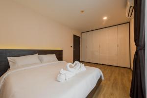 a bedroom with a white bed with towels on it at Zensation The Residence Bangkok in Bangkok