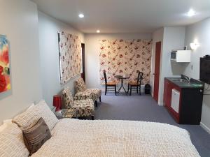 um quarto com uma cama, uma mesa e cadeiras em Anchor Down Bed & Breakfast em Picton