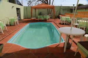 a small pool on a patio with a table and chairs at Pousada Victor in Ribeirão Claro