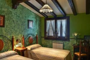Dormitorio verde con 2 camas y ventana en Hospedería Ruta de Lorca, en Alfacar