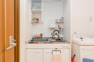a small kitchen with a sink and a stove at Awaza House 1 in Osaka