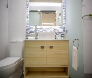 a bathroom with a sink and a toilet and a mirror at Room Motels Gatton in Gatton