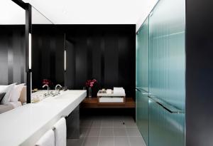 
a bathroom with a sink, mirror, and toilet at Crown Metropol Melbourne in Melbourne
